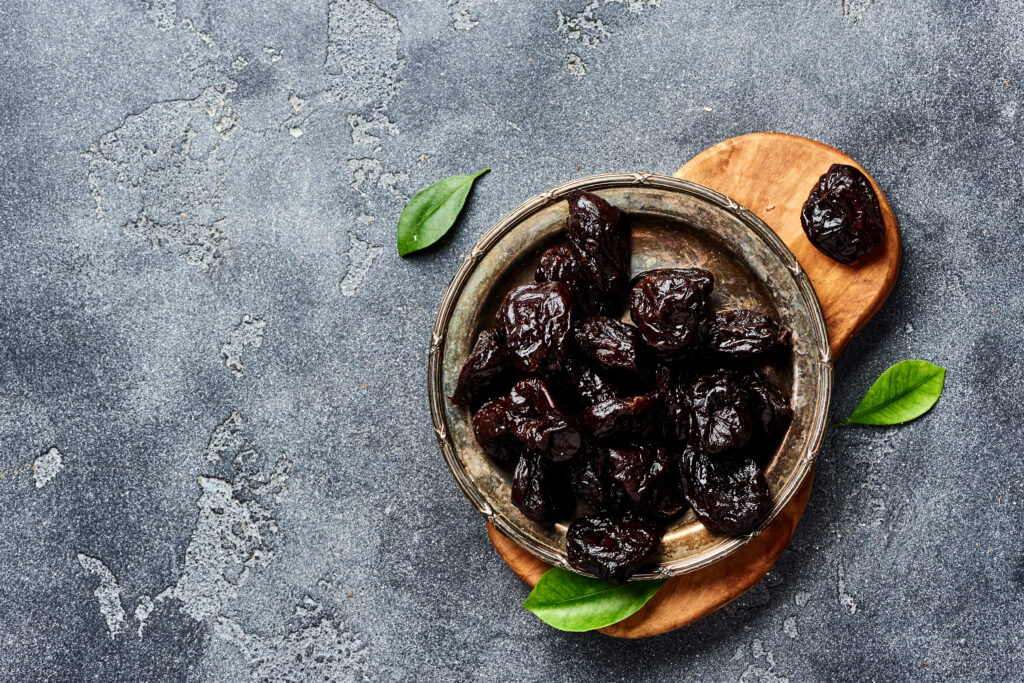 Dried prunes on plate. Top view of peeled plums