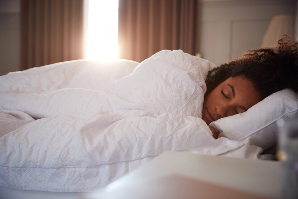 Woman sleeping peacefully in bed at dawn